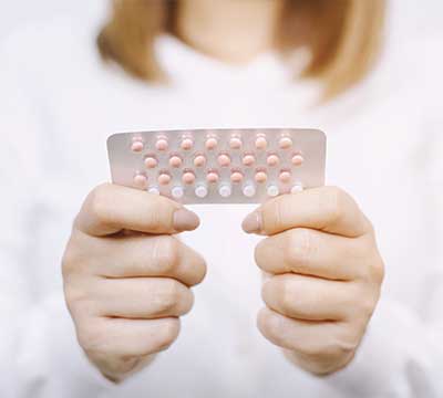 ピルを手に持つ女性