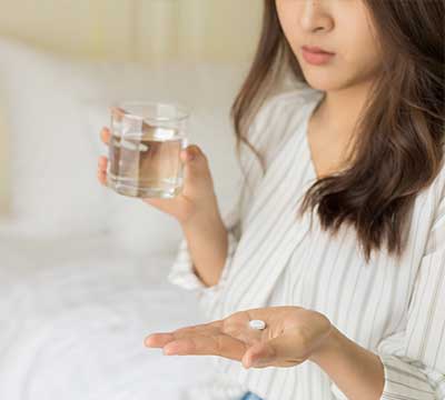 薬を飲む女性